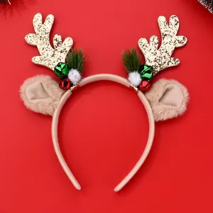 Detail of Christmas reindeer antler headband with gold glitter, bells and green pine needles