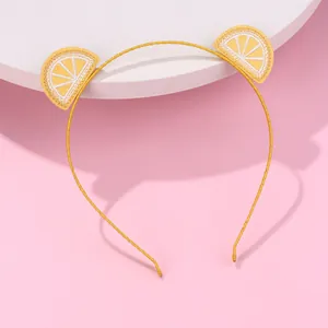 Detail of child hairband featuring cute yellow lemon embroidery on a bright yellow band