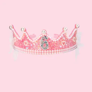 Gros plan du serre-tête rose à paillettes avec le chiffre 6 et détails en perles