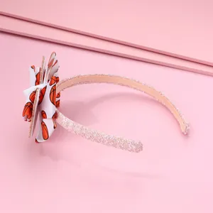 Détail d'un serre-tête rose pailleté avec nœud 3D à motifs de basket-ball imprimés