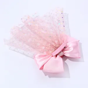 Détail de pince à cheveux avec nœud rose, paillettes en tulle et pince crocodile gainée