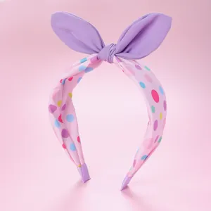 Détail du serre-tête rose à pois avec oreilles de lapin mauves et tissu doux