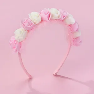 Close-up of pink and white fabric roses on a glittery floral headband for girls