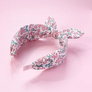 Detail of floral fabric headband with bow showing pink ribbed ribbon wrapped ends