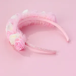 Close-up of pink and white rose headband with delicate mesh lace and glitter finish