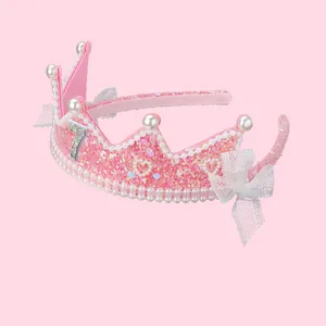 Détail d'un serre-tête couronne rose pailleté avec perles et chiffre sept pour fillettes
