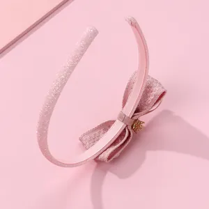 Serre-tête rose pailleté avec nœud en tissu et détail de pendentif couronne dorée