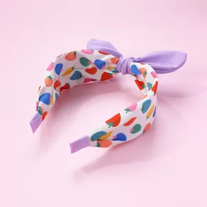 Détail de serre-tête avec imprimé fraises et nœud papillon violet pour fillettes