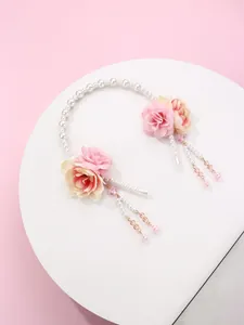 Detailed view of handmade pink floral hairpiece with pearls and hanging tassel fringe
