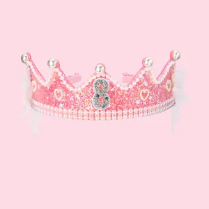 Gros plan d'un serre-tête couronne rose pailleté avec perles et chiffre 8 argenté