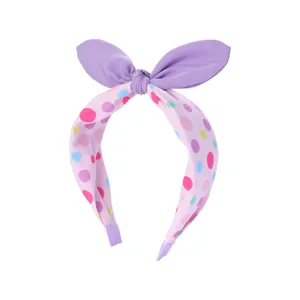 Détail d'un serre-tête rose à pois avec oreilles de lapin mauves en tissu doux