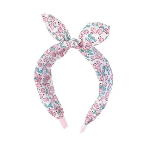 Close-up of floral fabric headband with a bow and pink elastic band details