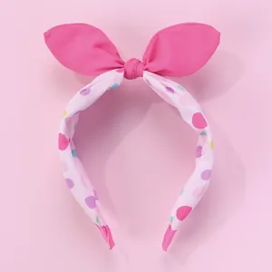 Gros plan d'un serre-tête oreilles de lapin rose avec motif à pois et tissu doux