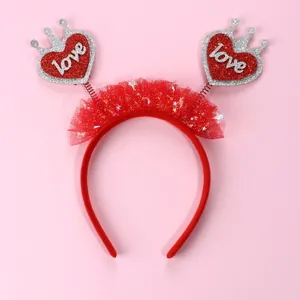 Dettaglio cerchietto rosso in tulle con cuori a molla, scritta love e paillettes argento