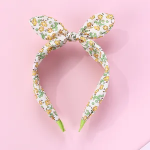 Detail of floral headband with bunny ear bow on pink background with fabric wrapping