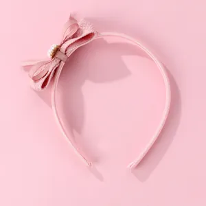 Gros plan détaillé du serre-tête rose scintillant avec nœud en tissu et perle