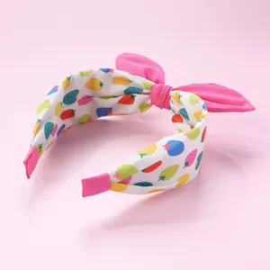 Détail du serre-tête rose à motif fraise avec un grand nœud en tissu 3D et ruban doux
