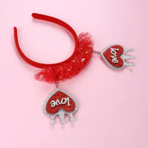 Dettaglio macro di cuori rossi glitterati con testo LOVE e corona in tulle su cerchietto