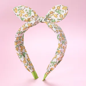 Detail of floral fabric headband featuring yellow flowers and a rabbit-ear bow design