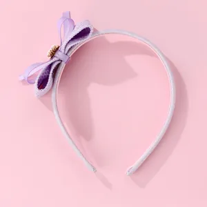Détail du serre-tête violet avec fini scintillant et nœud en tissu superposé