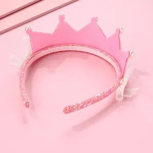 Détail d'un serre-tête couronne de princesse en feutre rose avec perles et dentelle fine