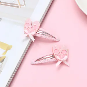 Detalle de horquillas rosas estilo zapatillas de ballet con corazones de brillo