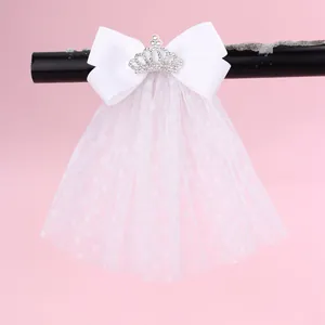 Détail de la pince à cheveux en tulle blanc avec couronne et nœud en ruban