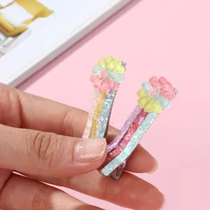 Dettaglio di fermagli per capelli con paillettes, fiori sfumati e base in metallo a becco