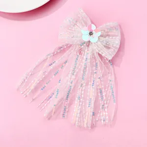 Détail de la pince à cheveux noeud en tulle rose à paillettes et fleur scintillante