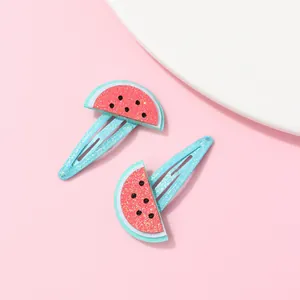 Detail of blue glitter hair clips with red sequin watermelon motifs for girls