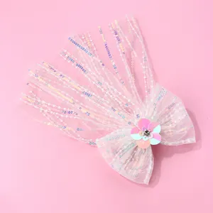 Détail d'un nœud en tulle à paillettes avec fleur dégradée et strass sur fond rose