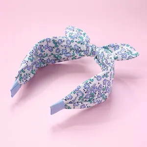 Detail view of floral print headband featuring a bow and non-slip ribbon wrapped ends