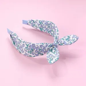 Close-up of floral fabric headband with blue fabric-sealed ends and bow detail