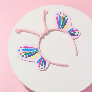 Detalle de diadema de mariposa rosa con purpurina, alas coloridas y antenas de felpa