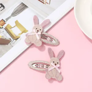 Set of two pink embroidered rabbit hair clips with cute bows on a stylish background