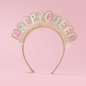 Detail of HAPPY QUEEN headband with glitter letters and white tulle on rose gold band