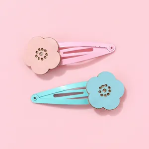 Detail of pink and blue floral hair clips with leather texture and golden glitter centers