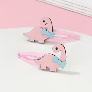 Gros plan de barrettes dinosaure roses avec nœud bleu sur support de présentation chic