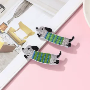 Close-up of cute cartoon dachshund embroidered hair clips with detailed textured stitching