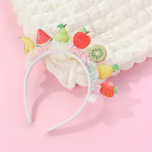 Detail of children's fruit headband with glitter charms and rainbow organza trim ruffle
