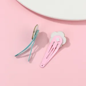 Detail of pink and blue floral hair clips with white felt flowers on a metal base