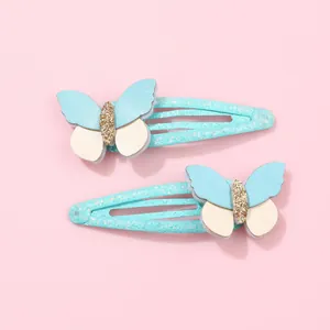 Dettaglio delle mollette per capelli a farfalla blu con glitter e paillette