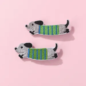 Detailed view of embroidered cartoon dachshund hair clips with colorful striped patterns