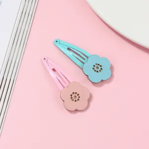 Detail of floral snap clips for girls in pink and light blue with golden center accents