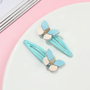 Dettaglio delle clip per capelli a farfalla con paillettes verde menta e strati in pelle