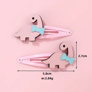 Gros plan des barrettes dinosaure rose avec dimensions 5.8cm x 2.7cm et poids de 2.84g