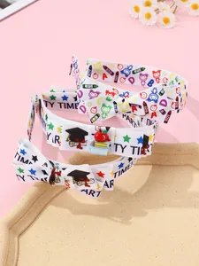 Detail of school themed bow hair accessory with printed crayons and resin book decoration