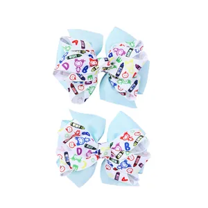 Détail de pinces à cheveux double couche avec rubans bleu clair et motifs de rentrée