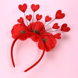 Dettaglio dei fiori in tessuto rosso e ciondoli a cuore sulla fascia festiva