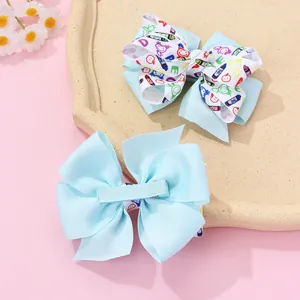 Détail de pinces à cheveux à nœuds bleu clair avec motifs de dessins animés et clips métal